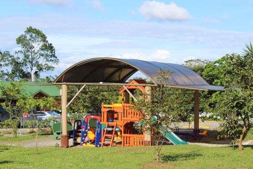 um parque infantil com um dossel e uma estrutura de jogos em Eco Granja Don Lolo em Quesada