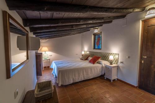 Schlafzimmer mit einem Bett, einem Tisch und einem Fenster in der Unterkunft Al Agia - Mirador Alto Cijancos in Padul