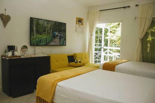 a bedroom with two beds and a tv on the wall at E 20 Mystic Ridge ocho Rios in Ocho Rios