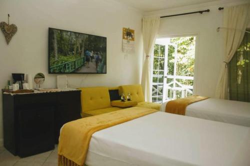 1 Schlafzimmer mit 2 Betten und einem TV an der Wand in der Unterkunft E 20 Mystic Ridge ocho Rios in Ocho Rios