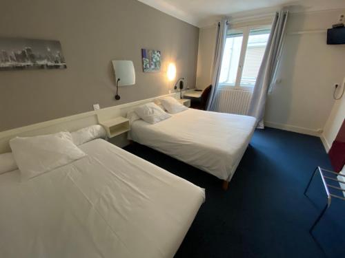 um quarto de hotel com duas camas e uma janela em Le Relais de Gascogne em Auch