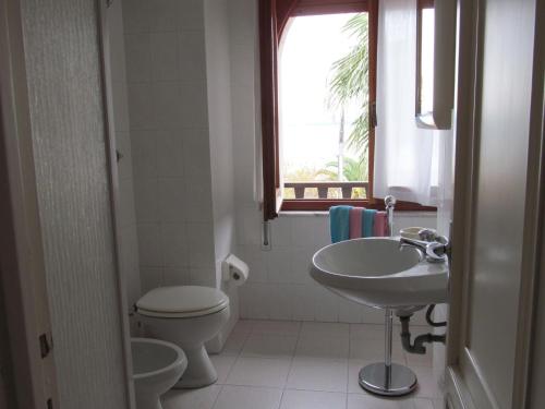 a bathroom with a sink and a toilet and a window at Luci del Golfo in Alghero