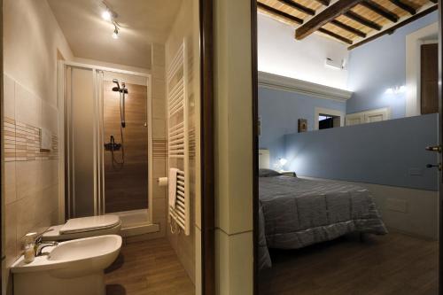 łazienka z prysznicem, toaletą i łóżkiem w obiekcie ROSSELLINO® w mieście Pienza