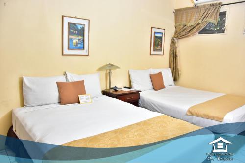 two beds sitting next to each other in a room at Hotel y Apartments Los Cisneros in Managua