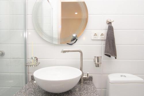 a white bathroom with a sink and a mirror at The Grand Piano Hotel in Kutaisi
