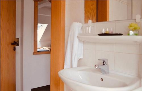 a white bathroom with a sink and a mirror at Boutique Hotel Selb in Selb