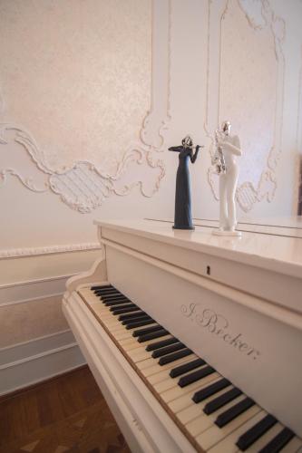 a white piano with a bride and groom figurine on it at The Grand Piano Hotel in Kutaisi