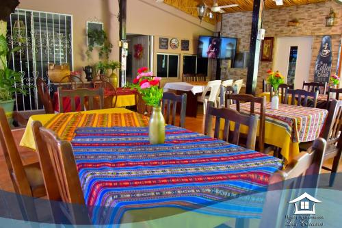 une salle à manger avec une table et un vase de fleurs. dans l'établissement Hotel y Apartments Los Cisneros, à Managua