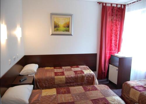 una habitación de hotel con 2 camas y cortinas rojas en Vabriku Guesthouse, en Tallin