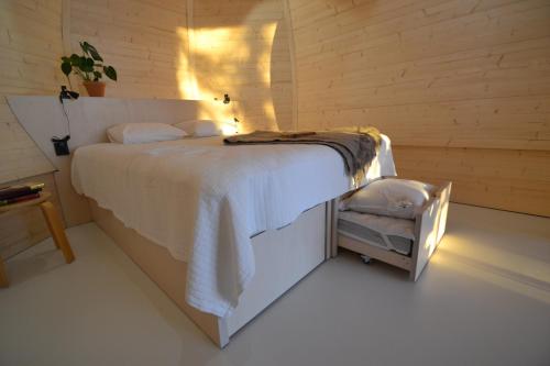 Un dormitorio con una cama con una manta blanca. en Ilveslinna en Laukaa