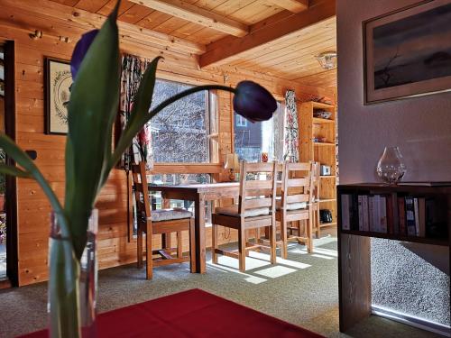 comedor en una cabaña de madera con mesa y sillas en Ferienwohnung Schmidt - Natur und Ruhe, en Schwaigen