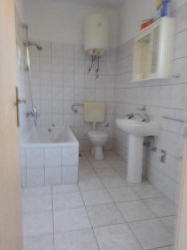 biała łazienka z umywalką i toaletą w obiekcie Apartmani Nedjeljka w mieście Viganj