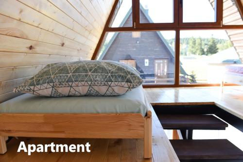 a bed in a tiny house with a large window at Lazar&Mila Apartments in Žabljak