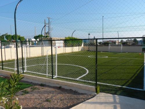 a soccer field behind a fence with a soccer ball at Anastasia Hotel Stalis in Stalida