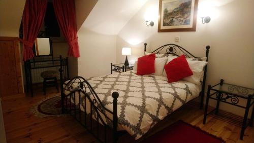 een slaapkamer met een bed met rode kussens bij Vaughans Pub/Accommodation in Clifden