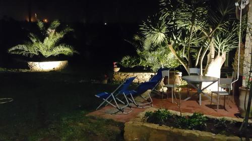 two chairs and a table in a yard at night at Palmeraie skhirat1 in Skhirat