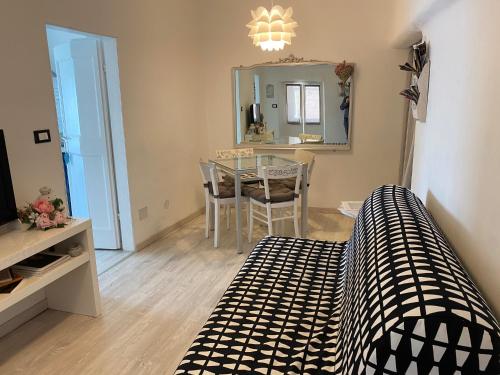 a living room with a table and a bed and a mirror at La Casetta di Dory sul Mare in Genova