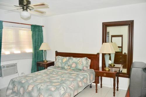 1 dormitorio con cama, escritorio y espejo en Waterway Condos, en Nassau