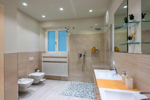 a bathroom with a shower and a toilet and a sink at casavacanza orchidea 2 in Bergamo