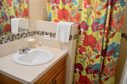 a bathroom with a sink and a shower curtain at Waterway Condos in Nassau