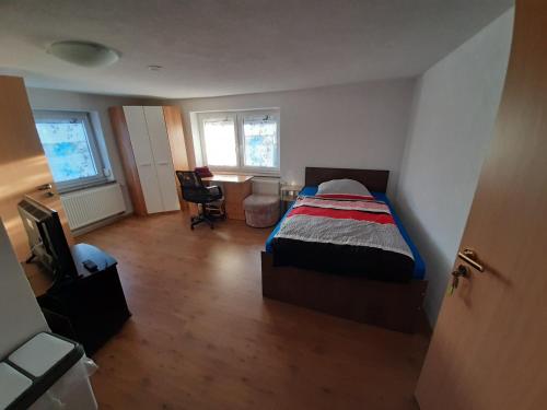 een slaapkamer met een bed, een bureau en een stoel bij Biberach-Riss-Zimmer-frei, Einzel-Zimmer Bad Küche in Birkenhard