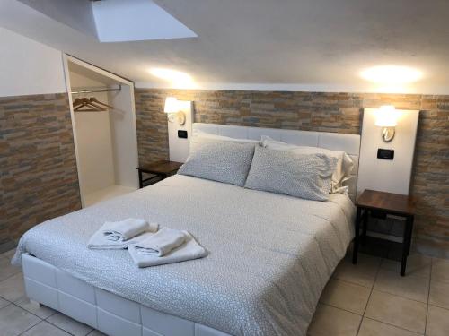 1 dormitorio con 1 cama grande y toallas. en B&B Il Viaggiatore, en Marina di Massa