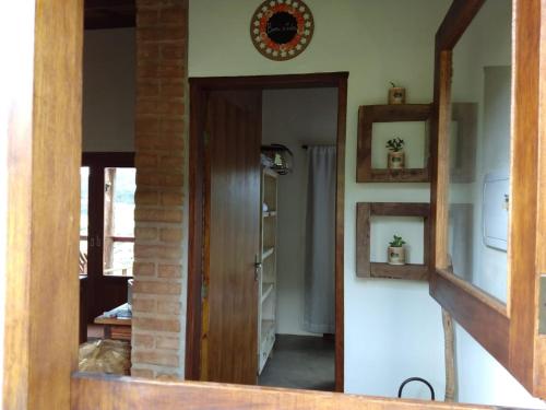 einen Flur mit Tür und Spiegel in einem Zimmer in der Unterkunft Casa Vista da Lagoa in Gonçalves