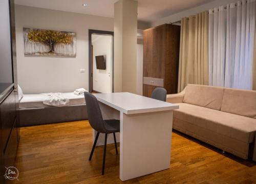 sala de estar con sofá, mesa y sillas en Suite Terrace Rooms & Apartments en Korçë
