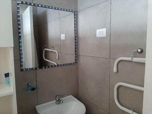 a bathroom with a mirror and a toilet and a sink at Hostal Los Castaños in Viña del Mar