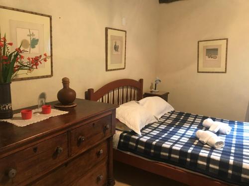 a bedroom with a bed and a dresser with towels at Solar Picu Eco-hospedaria in Itamonte