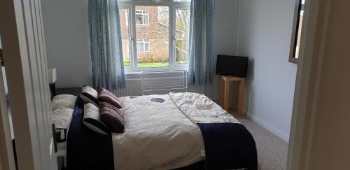 a bedroom with a bed with pillows and a window at Cobblestones in Benington