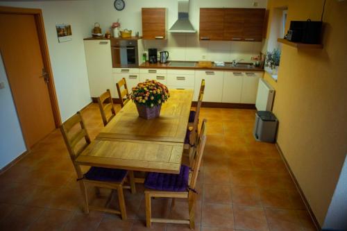eine Küche mit einem Holztisch mit Blumen darauf in der Unterkunft Gästehaus Schulz in Schenkendöbern