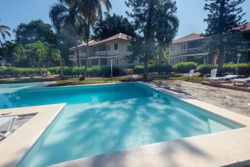 a swimming pool in front of a house at El Pelicano Apart-Hotel in Las Galeras