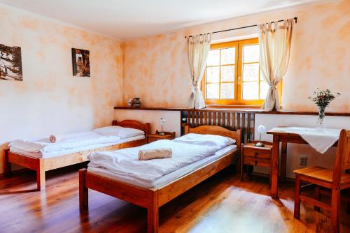 a bedroom with two beds and a window at Stará Škola in Košariská-Priepasné