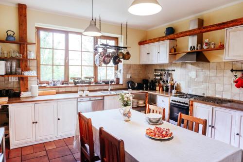 a kitchen with white cabinets and a table and chairs at Stará Škola in Košariská-Priepasné