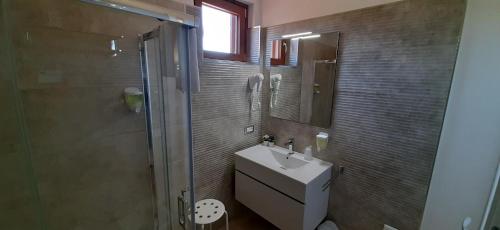 łazienka z umywalką, prysznicem i lustrem w obiekcie DONJON SUITE centro storico w mieście Castelbuono