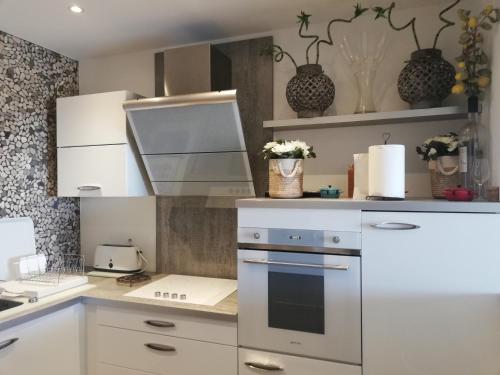 une cuisine avec des armoires blanches et un four à plaques de cuisson dans l'établissement APPARTEMENT T2 IMPERIAL, à Ajaccio