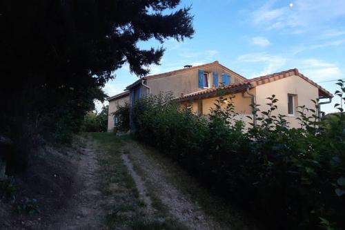 a house on a dirt road next to a field at Studio dans un cadre champêtre in Mas-Saintes-Puelles