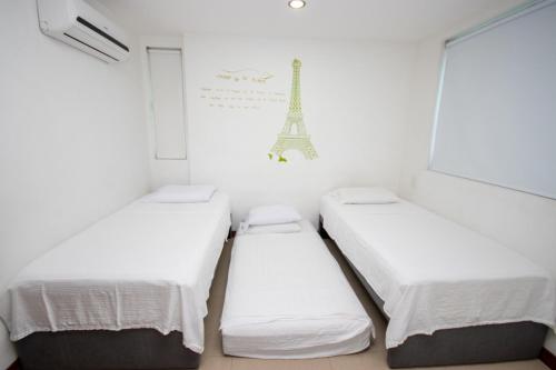 - 3 lits dans une chambre avec la tour Eiffel dans l'établissement Excelente Apartamento Palmetto con vista al mar, à Carthagène des Indes