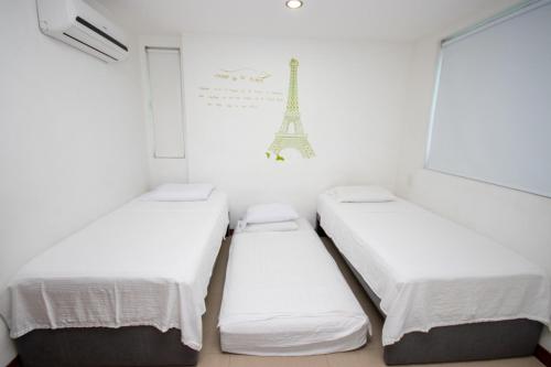 3 camas en una habitación con la torre Eiffel en Excelente Apartamento Palmetto con vista al mar, en Cartagena de Indias