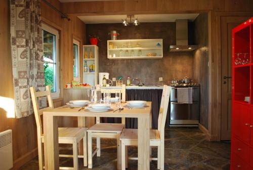 eine Küche mit einem Holztisch und Stühlen im Zimmer in der Unterkunft Le Chalet à Bonnerue in Houffalize