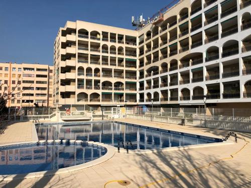 a large building with a swimming pool in front of it at Turquesa 10 in La Pineda