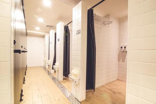 a bathroom with a shower, sink, and mirror at Ahiruyah Guesthouse in Kaohsiung