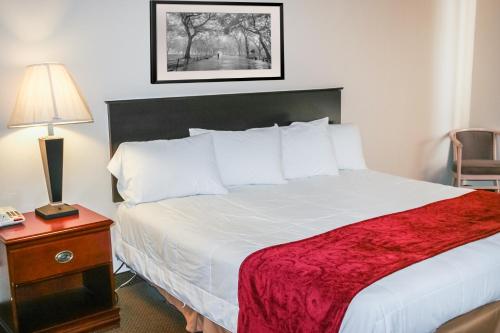ein Hotelzimmer mit einem großen Bett mit einer roten Decke in der Unterkunft Hotel 7 Inn Vienna in Vienna