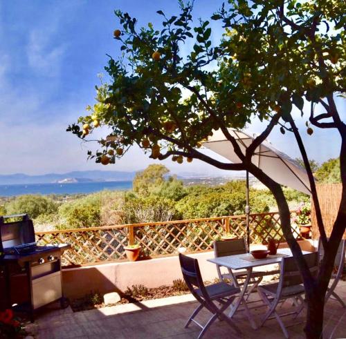 a table and chairs on a patio with a tree at Casa Limone in Quartu sant Elena, Capitana, with sea view! in Capitana