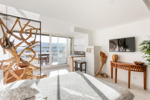 Cet appartement comprend une chambre avec un lit et une cuisine avec un balcon. dans l'établissement Bali Heliopolis naturiste, au Cap d'Agde