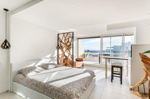 une chambre avec un lit et une vue sur l'océan dans l'établissement Bali Heliopolis naturiste, au Cap d'Agde