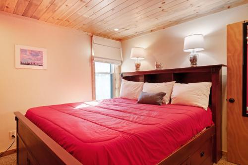 a bedroom with a large red bed with two lamps at Lodgepole Condos in Silverthorne