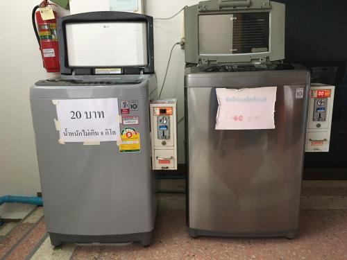 un televisor y una máquina sentados uno al lado del otro en J-2 Court en Songkhla