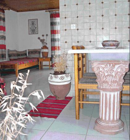 a room with a table and a chair and a vase at Kyra's Paradise in Potistika